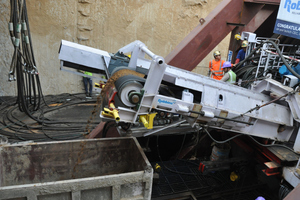  	Muck begins to roll off the TBM conveyor – ground consists of mostly silty sand above the water table 