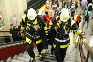  Four emergency personnel carrying a mobility-restricted person 