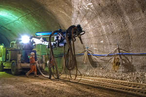  After blasting, the tunnel workers secure the tunnel surface with shotcrete. Concrete and accelerator mix in the shotcrete buffalo 