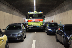  Einsatz der Feuerwehr Dietikon im 3,2 km langen Gubrist-Tunnel im Juni 2012 (links): Das Löschfahrzeug kommt im zweispurigen Straßentunnel nicht weiter voran. Blick um 180 gewendet (rechts): Die Löscharbeiten sind dennoch zeitlich parallel bereits angelaufen; dabei sorgen die alle 265 m angeordneten Querschläge, das Problem der Eindringtiefe betreffend, für gute Arbeitsvoraussetzungen 